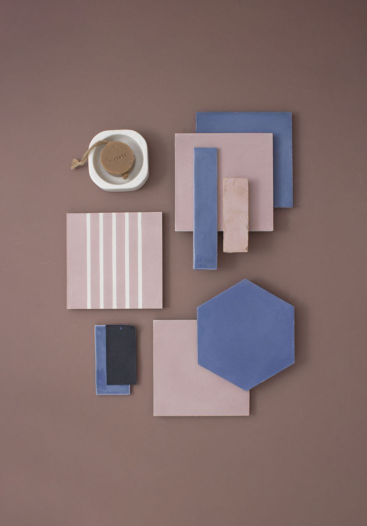 several pieces of paper and a cup on a brown surface with one piece missing from it