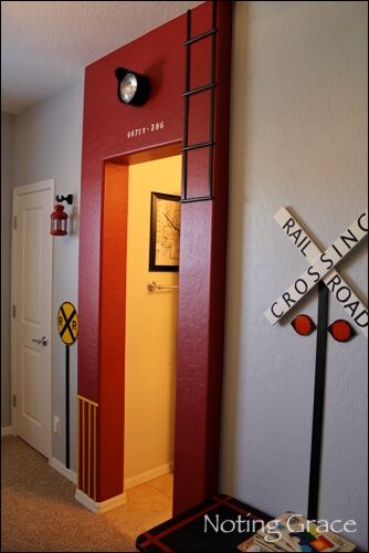 a hallway with a red door and some signs on the wall next to an entry way