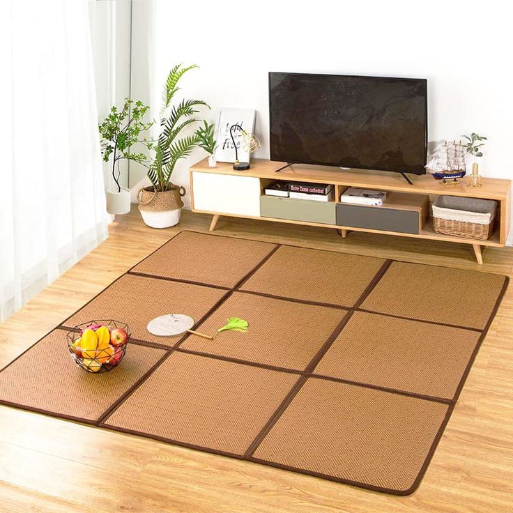 a flat screen tv sitting on top of a wooden stand in a living room next to a potted plant