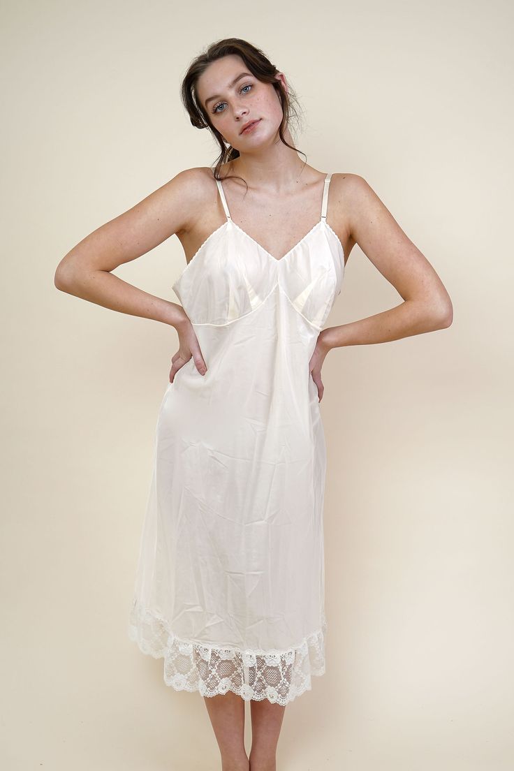 Sweet and simple romantic cottage core inspired circa 1970s nylon slip, pretty enough to wear as a nightgown as well. Fitted cups (love the double darting detial!) with adjustable ribbon straps, petite lace trim around the neckline and underbust, and a-line skirt with triple lace trim. Soft, vanilla cream nylon jersey fabric. Slips on overhead for wear Adjustable straps Care: hand wash cold / line dry Fit Notes & Other Info Model Olivia: Height: 5'9" Bust: 33" Waist: 26" Hip: 35" Buying & Wearin Silk Lace Nightdress, Vintage Slip Dress Outfit, White Silk Nightgown, Silk Nightdress, Beautiful Nightgown, Slip Dress Outfit, Vintage Slip Dress, Silk Nightgown, Romantic Cottage