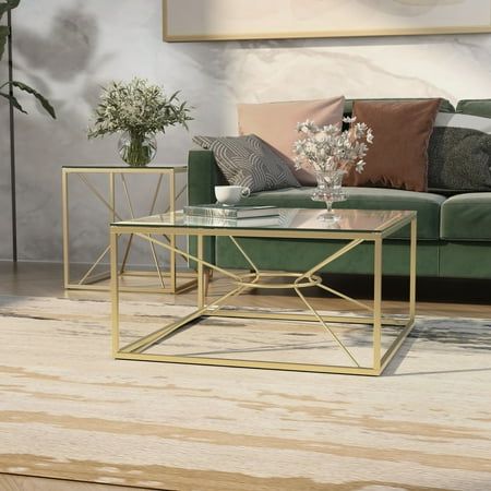 a living room with a green couch, coffee table and potted plants on the floor