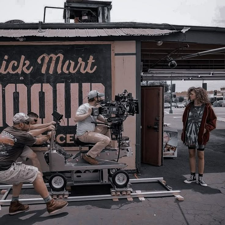 some people are filming in front of a sign