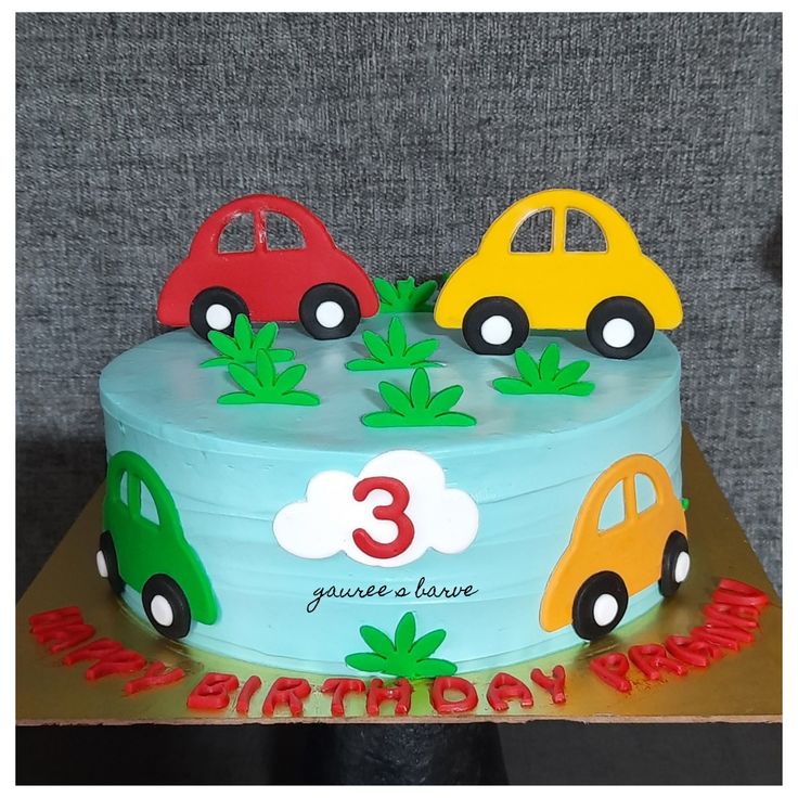 a birthday cake with three cars on it