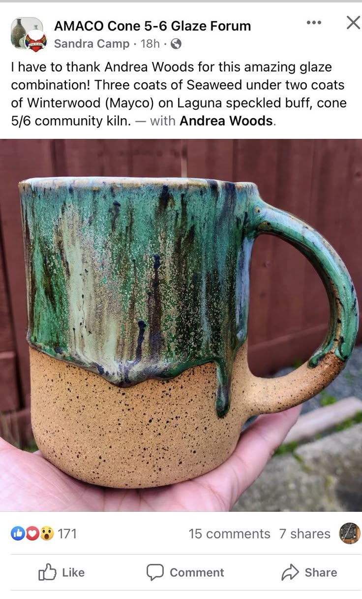 a hand holding a green and brown coffee mug