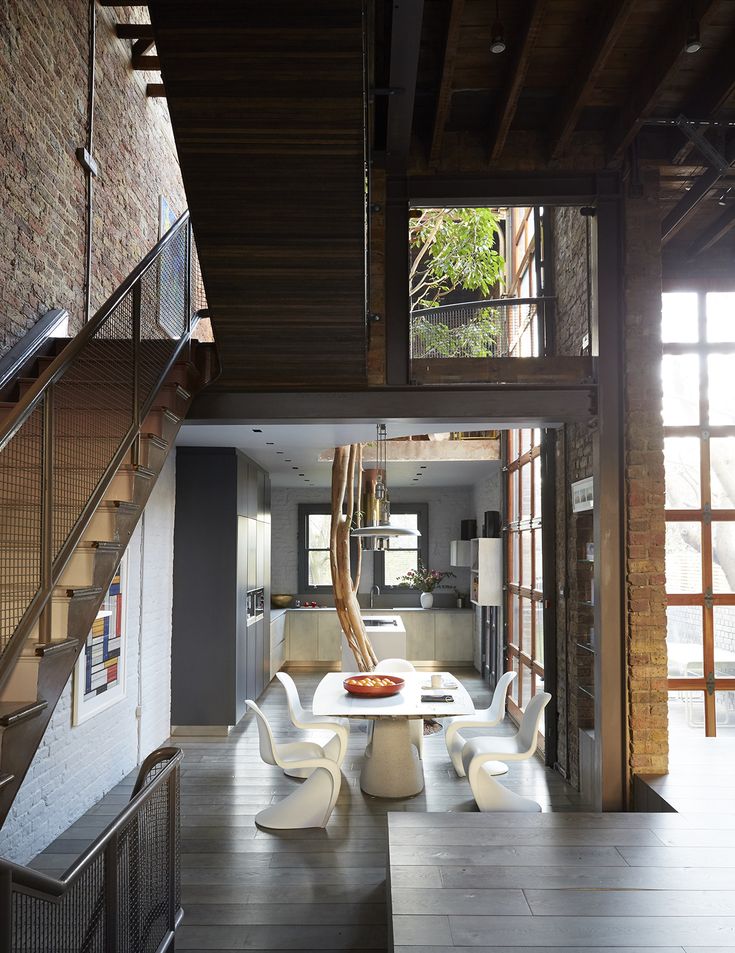 an open living room and dining area with stairs leading up to the second floor