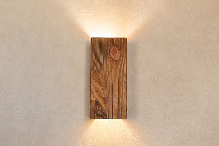 a wooden wall light mounted to the side of a wall