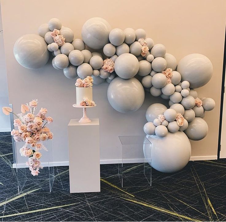 balloons and flowers are on display in front of a wall