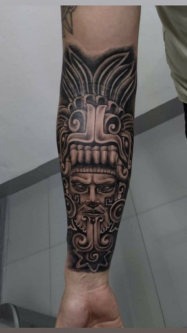 a man's arm with a tattoo on it and an image of a mask