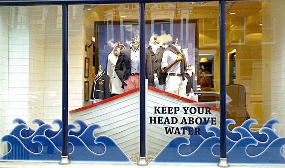 a store window with an advertisement on the front and behind it that says keep your head above water