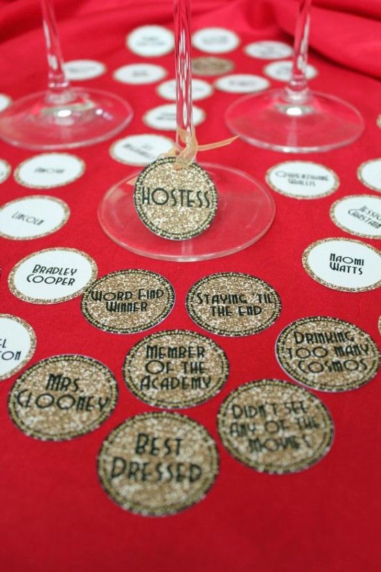 some wine glasses are sitting on a red tablecloth with white and gold confetti