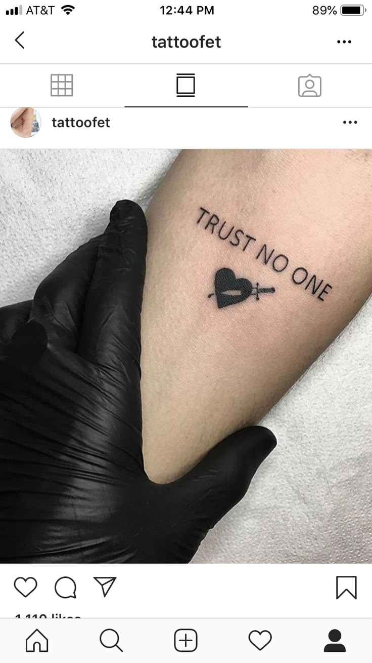 a tattoo with the words trust no one on it and an arrow in the shape of a heart