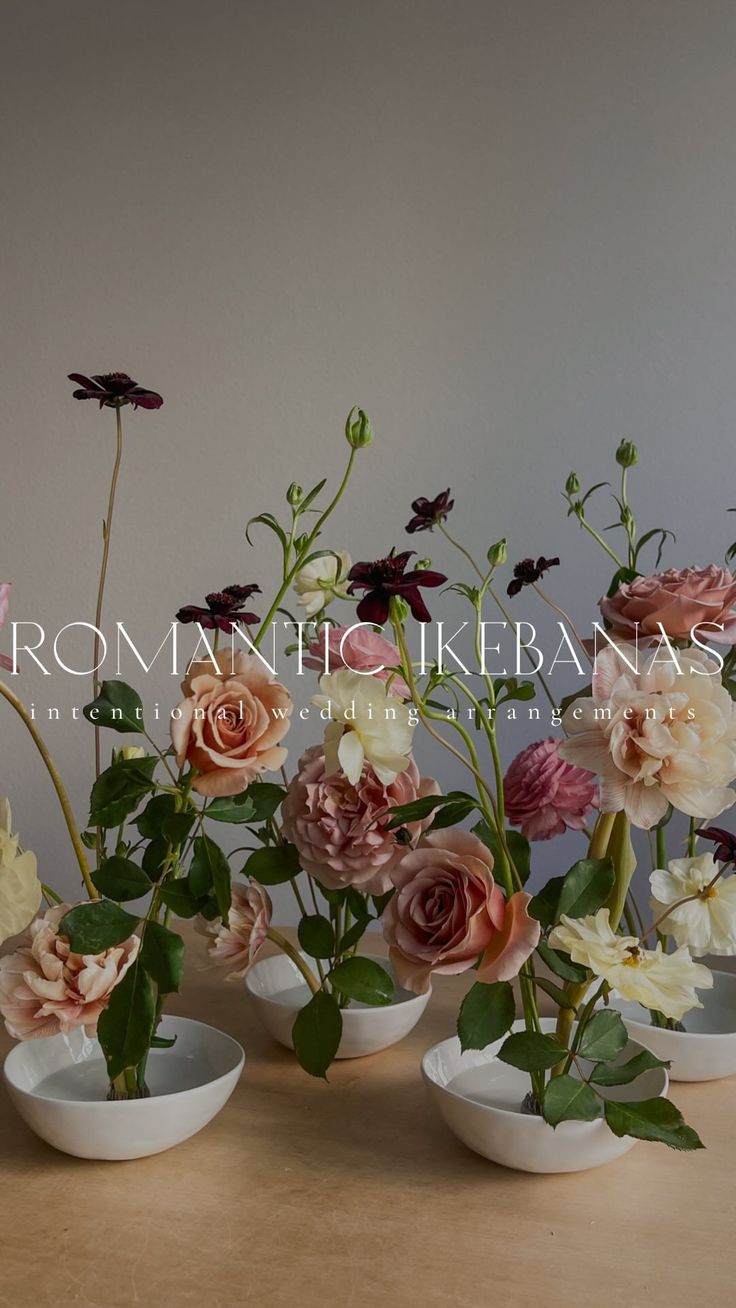 three white bowls filled with flowers on top of a table