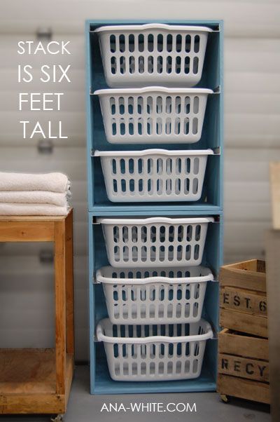 three white laundry baskets stacked on top of each other in front of a blue shelf