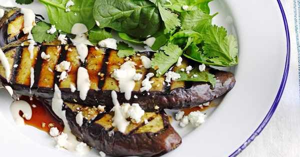 grilled eggplant with feta cheese and lettuce on a white plate