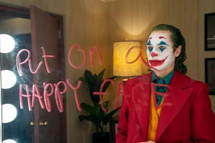 the joker is standing in front of a sign that says don't be happy