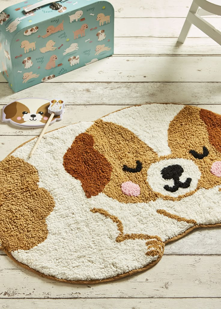 a brown and white dog rug sitting on top of a wooden floor next to a suitcase