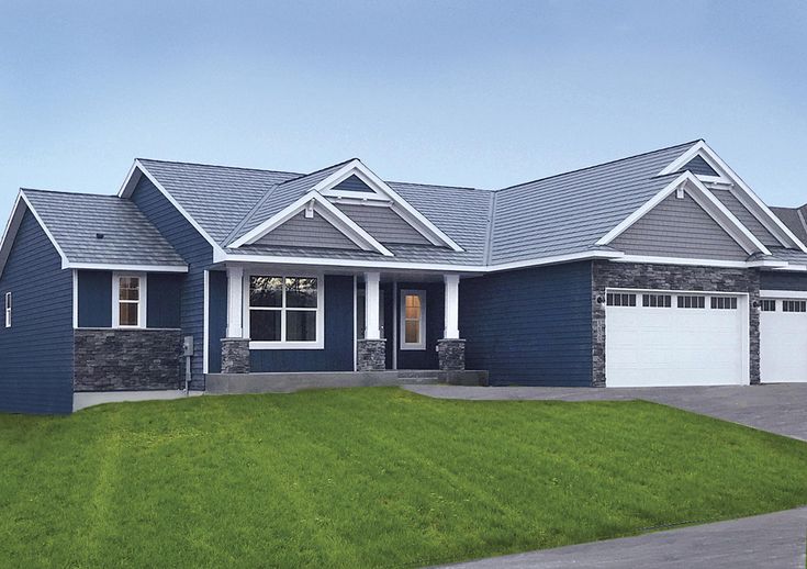 a blue house with two garages on the front