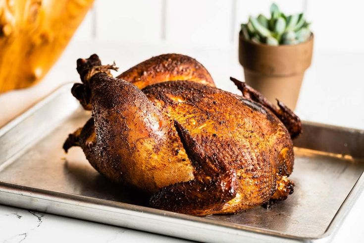 a roasted chicken sitting on top of a metal pan