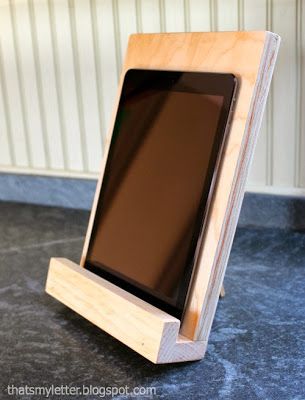 an electronic device sitting on top of a wooden stand next to a black countertop