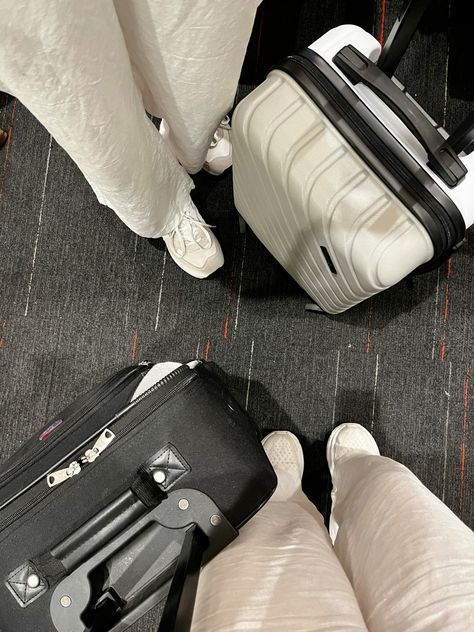 two pieces of luggage sitting on the floor next to each other with their feet propped up