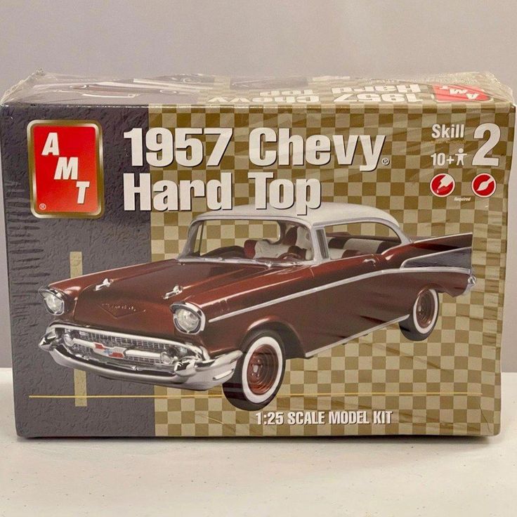 an old model chevrolet hard top car in a box on a white table with checkered background