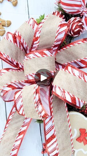 a close up of a christmas wreath on a white wooden surface with candy canes