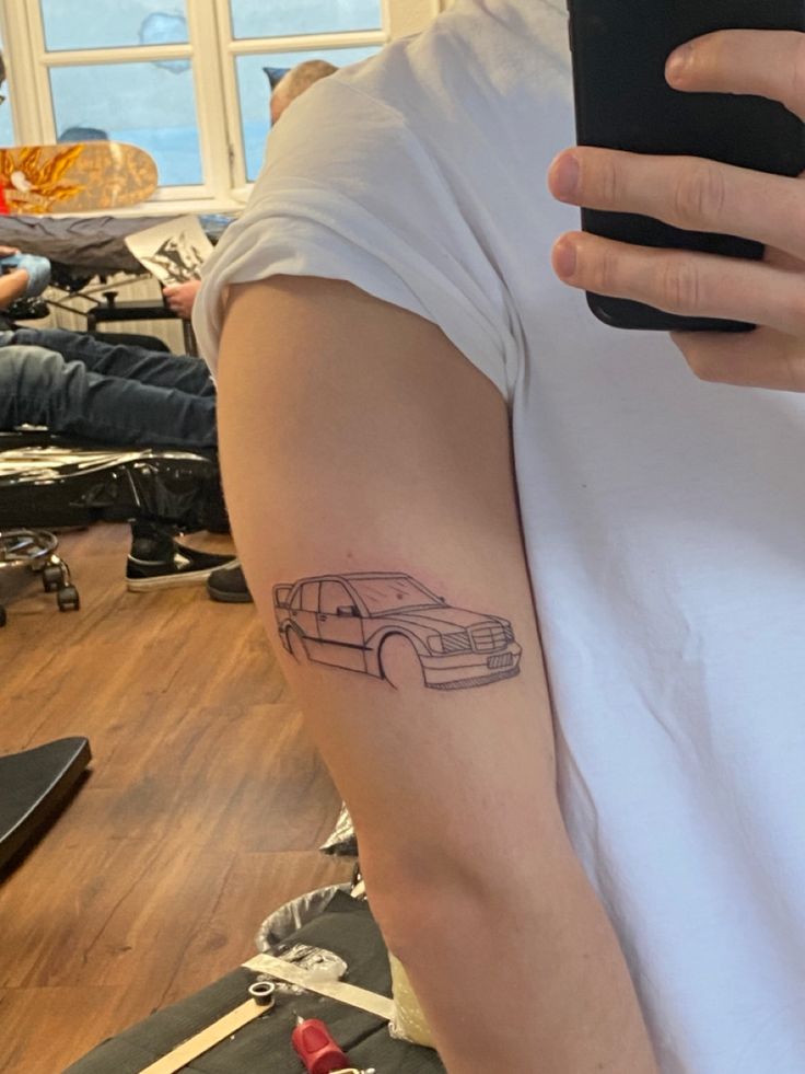 a person with a car tattoo on their arm