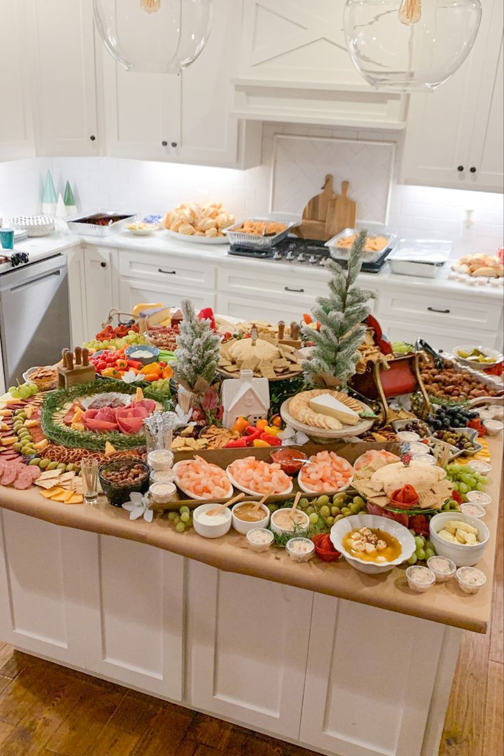 a large table filled with lots of food on top of a kitchen counter