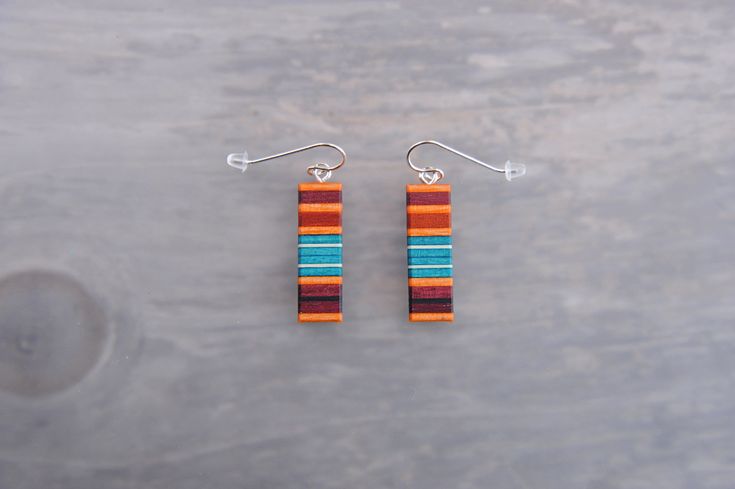 These ultra lightweight Rectangle Statement earrings combine the simplicity and versatility of modern design with the bright warmth of southwest colors. This pair of earrings is made from reclaimed African Ebony, Purpleheart, Holy, Paela, turquoise dyed white Maple, and Redheart woods. Finished with Surgical Steel, 14k rose gold filled, 14k yellow gold, or solid Sterling Silver fish hook ear wires. Hypoallergenic and almost weightless. Designed and handmade by Josiah Eidmann in Kenosha, WI. Ships safely packaged in a cotton filled gift box. Southwest Colors, Spring Fashions, Polymer Clay Diy, Silver Fish, Paper Jewelry, Etsy Earrings Dangle, Fish Hook, Silver Wire, Ear Wires