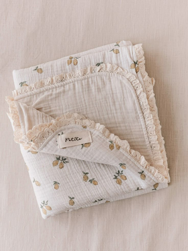 two pieces of white fabric with pineapples on them, one is folded and the other has ruffled edges