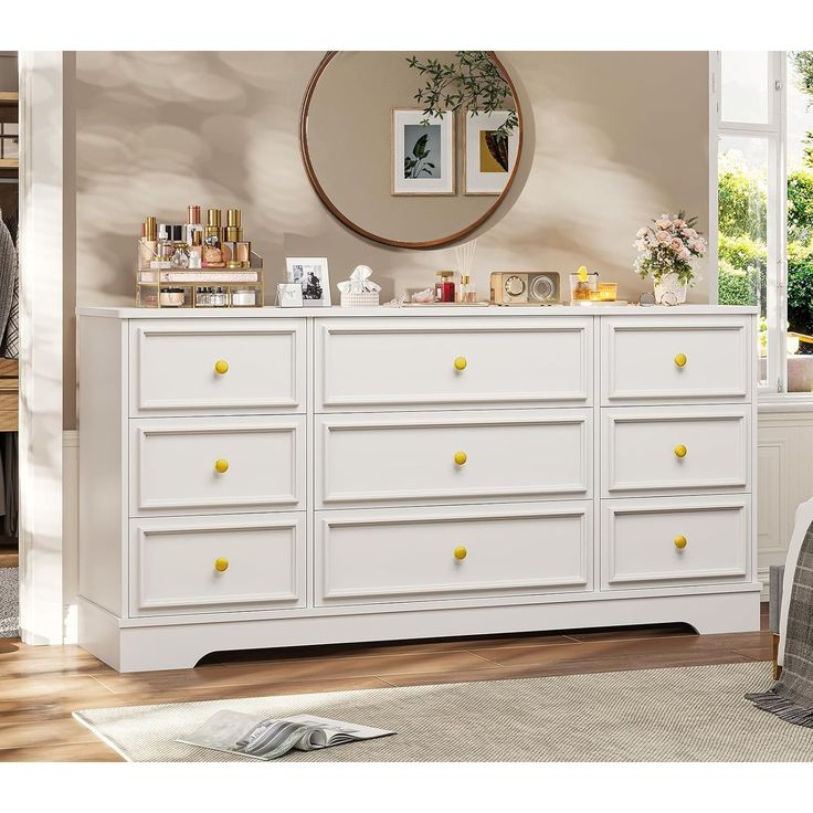 a white dresser with yellow knobs in a room