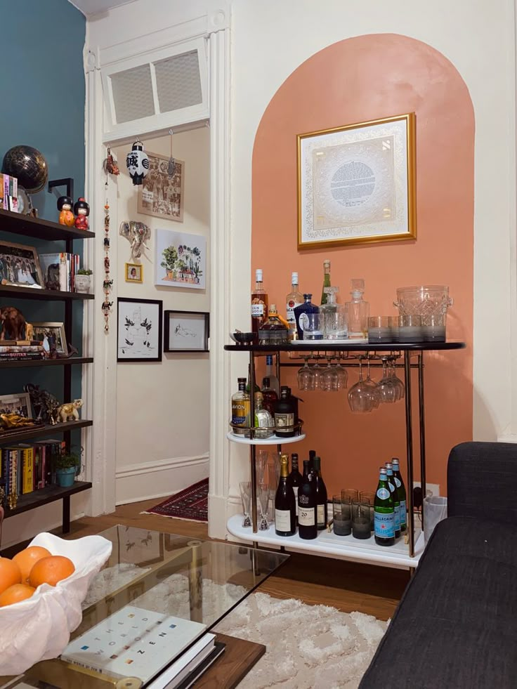 a living room filled with lots of furniture and bottles on top of a glass table