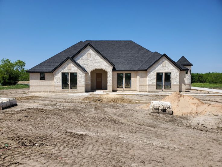 a house is being built in the middle of an empty lot with dirt on the ground