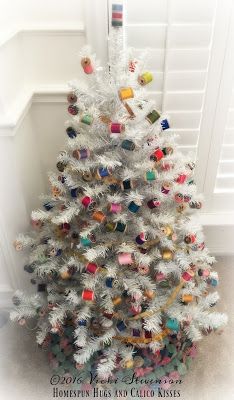 a white christmas tree with colorful ornaments on it