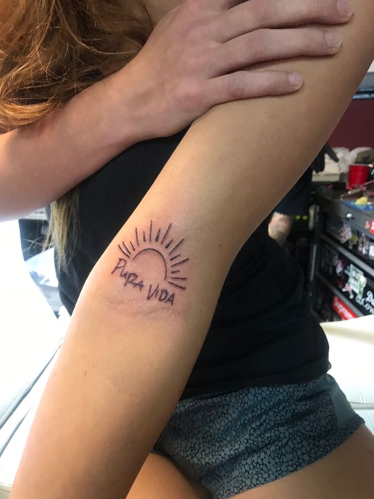 a woman with a sun tattoo on her arm and the words you've got