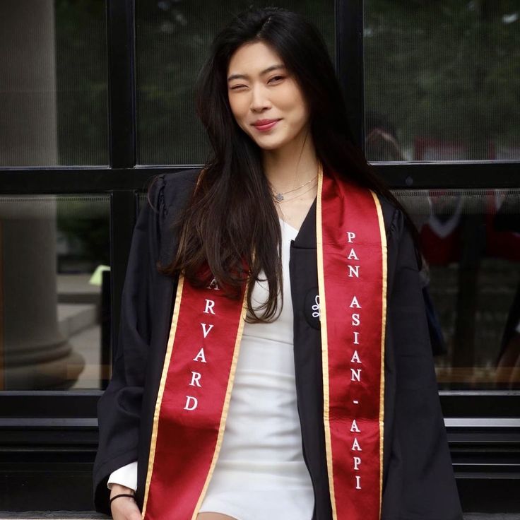 a woman wearing a red and gold graduation stole