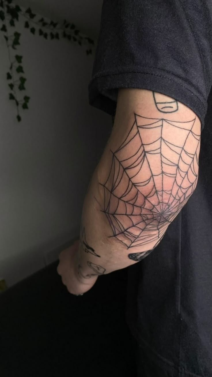 a person with a spider web tattoo on their arm