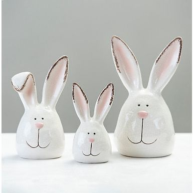 three white ceramic rabbits sitting next to each other