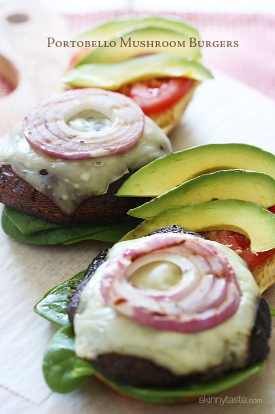 three sandwiches with avocado, tomato and onion on them