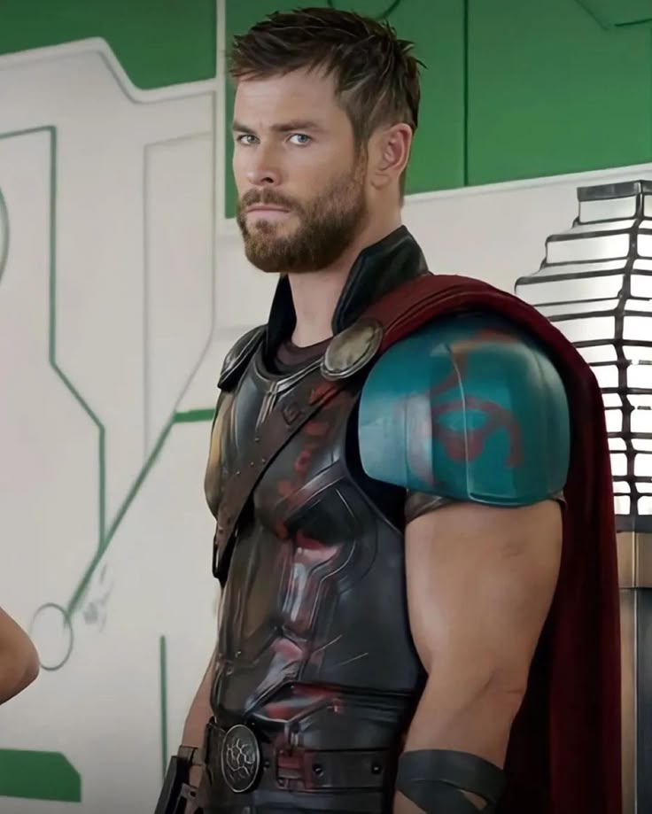 a man dressed as thor from the avengers movie standing in front of a green and white wall