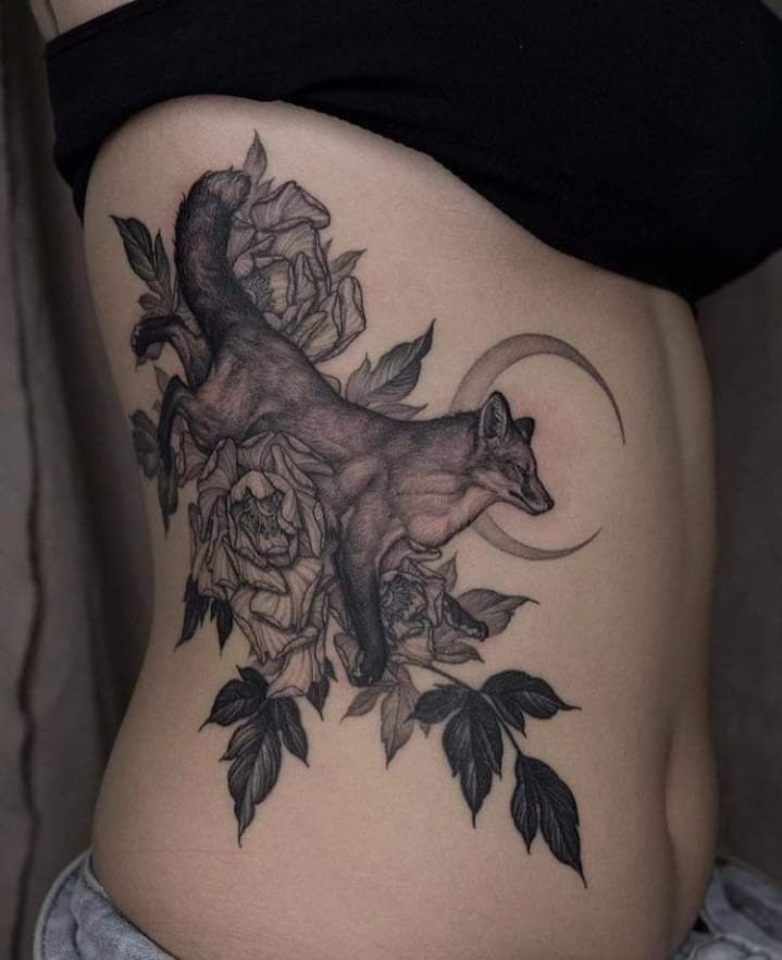 a woman's stomach with an animal and flowers tattoo on the side of her body