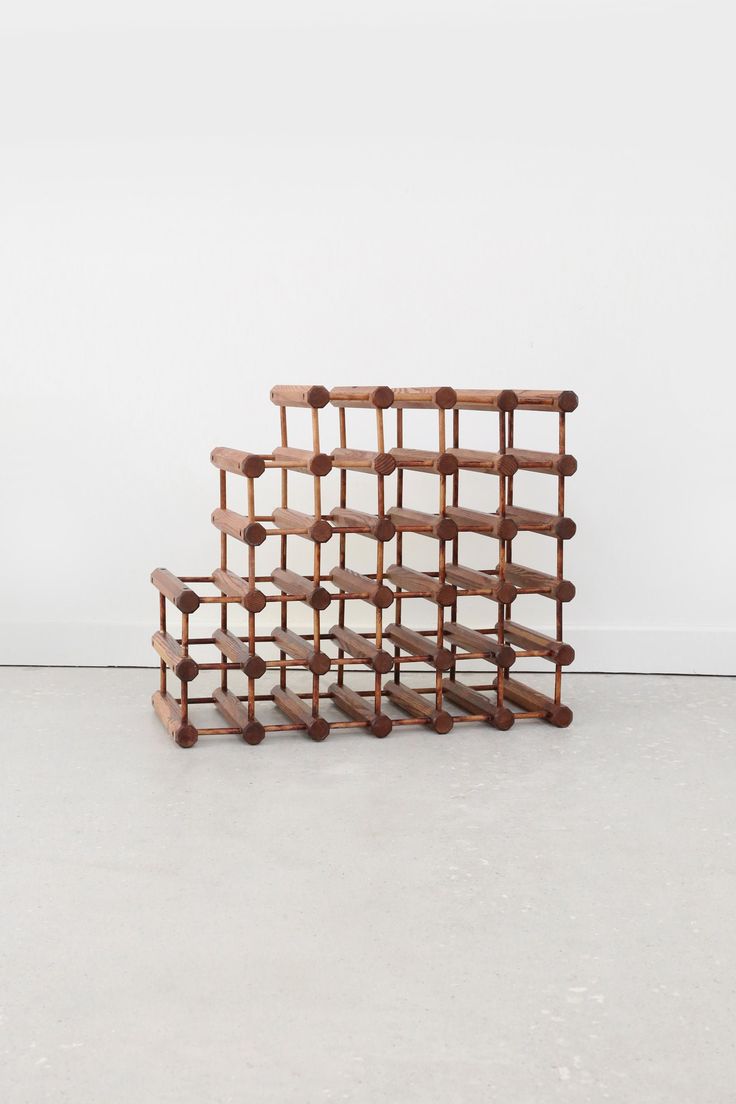 four wooden shelves stacked on top of each other in the middle of a room with white walls