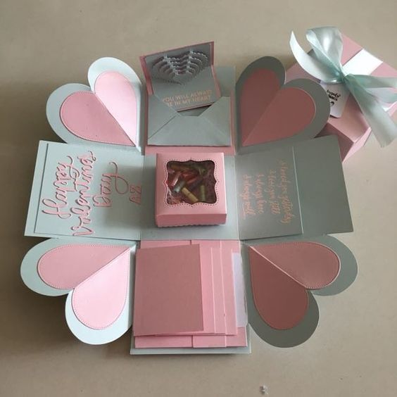 pink and grey boxes with hearts on them are arranged in the shape of a heart