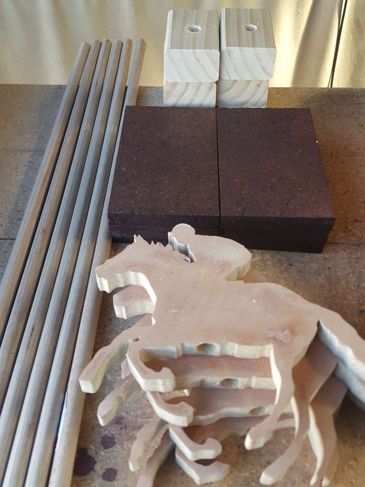 several pieces of wood sitting on top of a table next to metal rods and square blocks