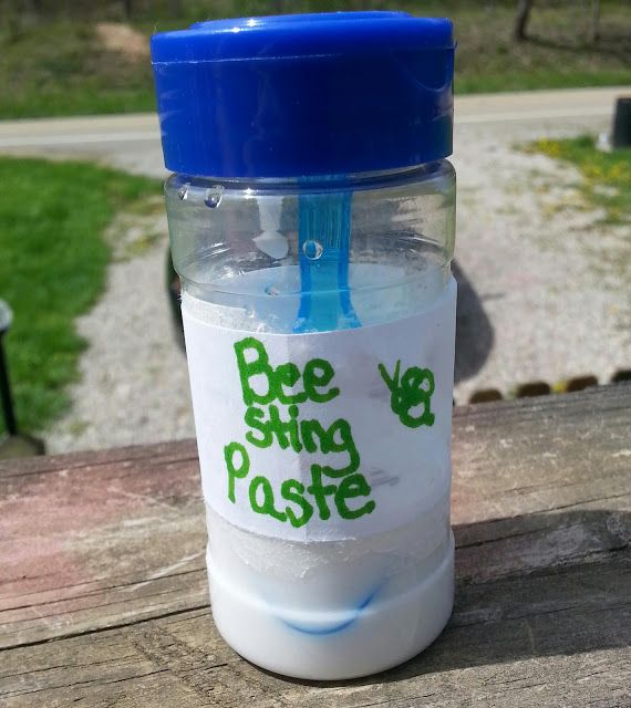 a plastic water bottle with a straw sticking out of it sitting on a picnic table