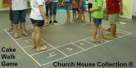 a group of people standing around in front of a game on a floor with a basketball court