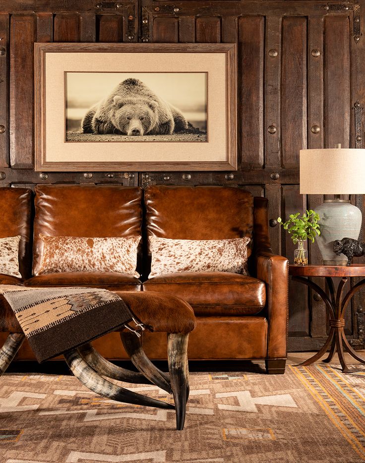 a living room filled with furniture and a framed animal print on the wall above it