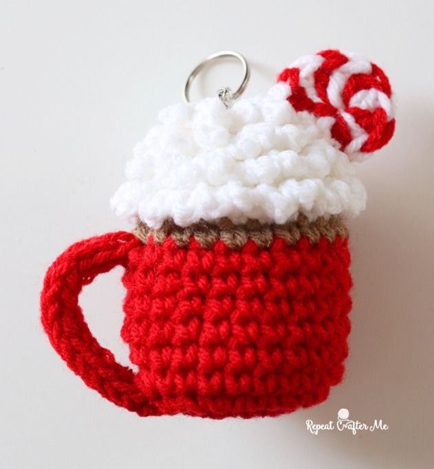 a crocheted coffee cup keychain with a candy cane on top