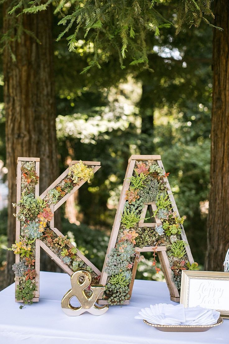 the letters are made out of succulents on top of a table