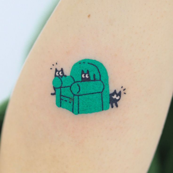 a green couch with two cats sitting on it's back and one cat laying down